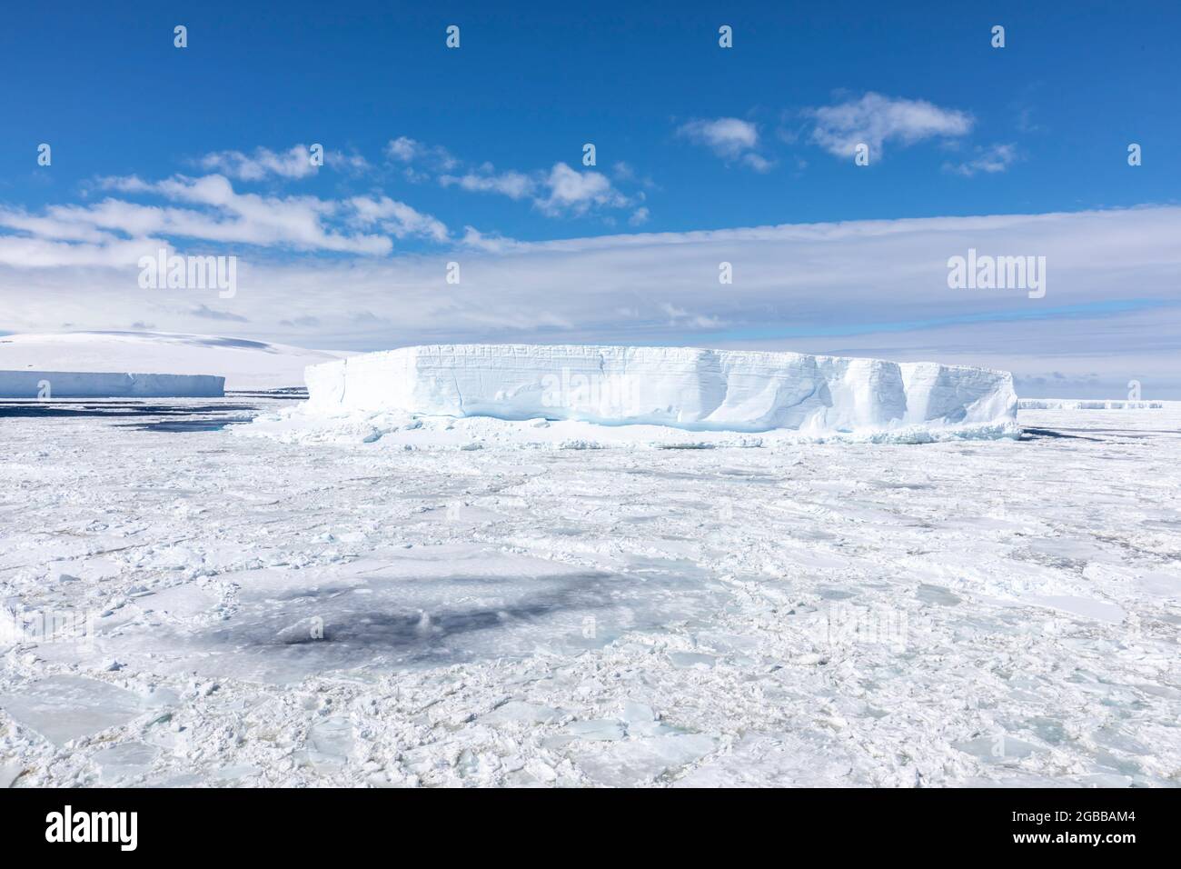 Iceberg tra i ghiacci marini invernali che si rompono nel Mare di Weddell, Antartide, regioni polari Foto Stock