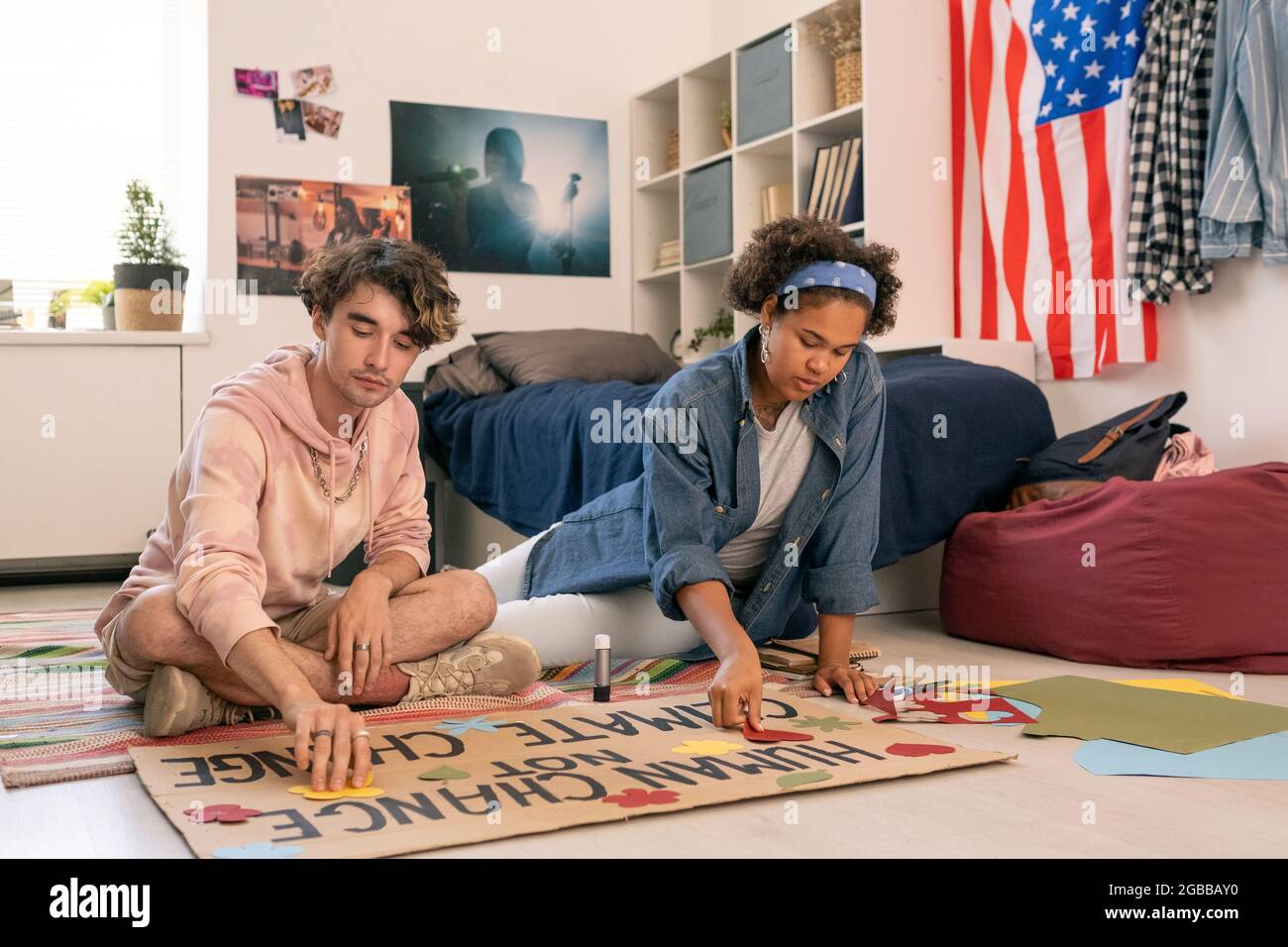 Due progettisti adolescenti che lavorano sulla carta da progetto climatica in ambiente domestico Foto Stock