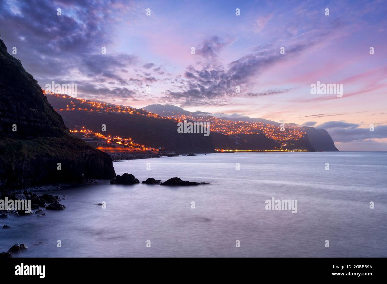 Tramonto sul villaggio costiero illuminato di Ponta do Sol, isola di Madeira, Portogallo, Atlantico, Europa Foto Stock