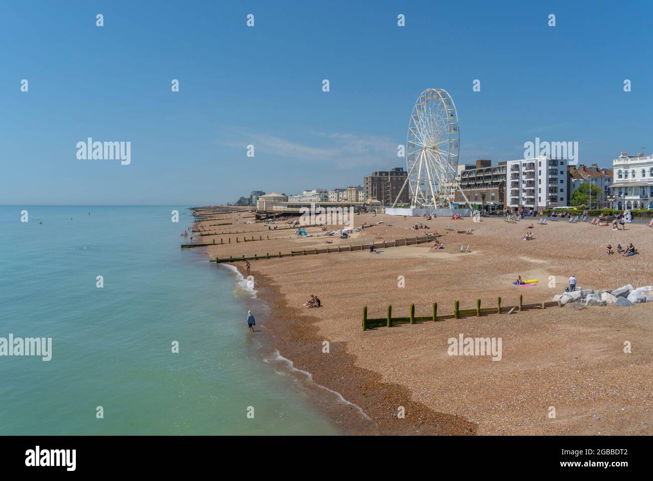 Vista delle case fronte spiaggia e ruota panoramica dal molo, Worthing, West Sussex, Inghilterra, Regno Unito, Europa Foto Stock