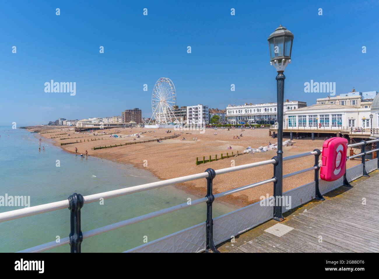 Vista delle case fronte spiaggia e ruota panoramica dal molo, Worthing, West Sussex, Inghilterra, Regno Unito, Europa Foto Stock