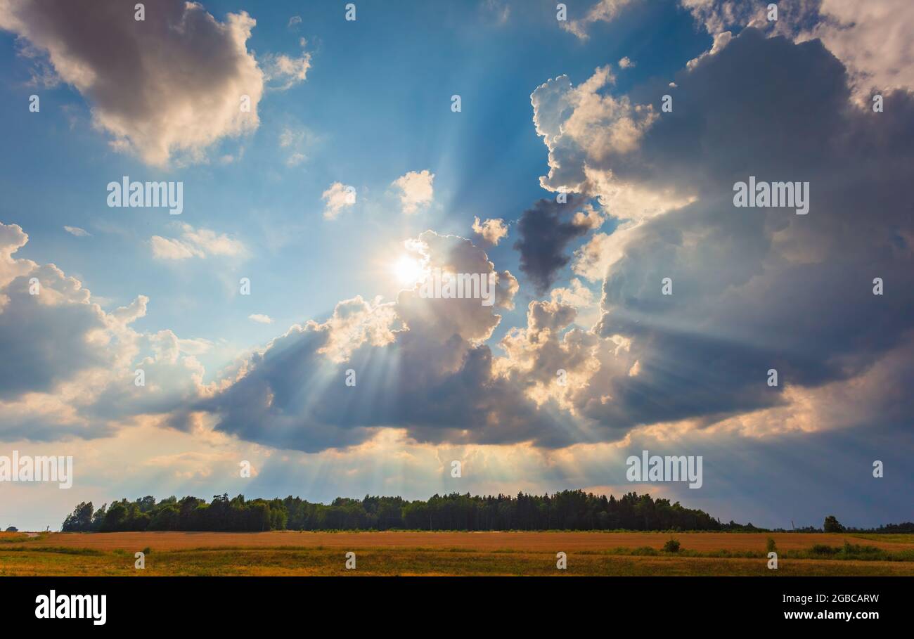 Raggi del sole che emergono attraverso nuvole soffici, fiducia e speranza, cielo Foto Stock