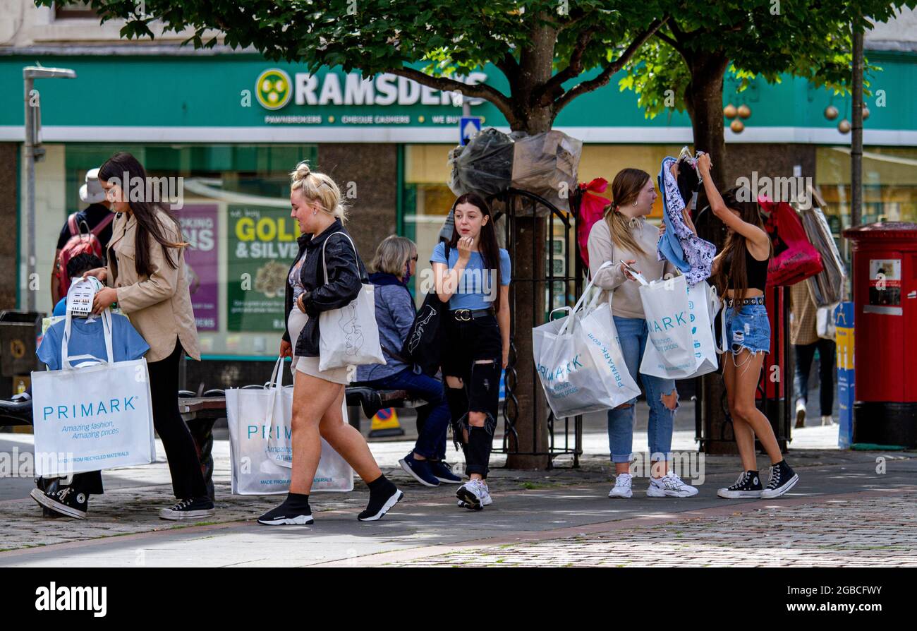 Dundee, Tayside, Scozia, Regno Unito. 3 agosto 2021. Regno Unito Meteo: Caldo e soleggiato in tutto il Nord-Est della Scozia con temperature che raggiungono i 20°C. La mini ondata di caldo riunisce molte persone all'aperto per godersi il caldo e glorioso clima di sole nel centro di Dundee. Giovani donne alla moda insieme mostrando a vicenda ciò che avevano comprato dopo una giornata di shopping al negozio di moda Primark. Credit: Dundee Photographics/Alamy Live News Foto Stock