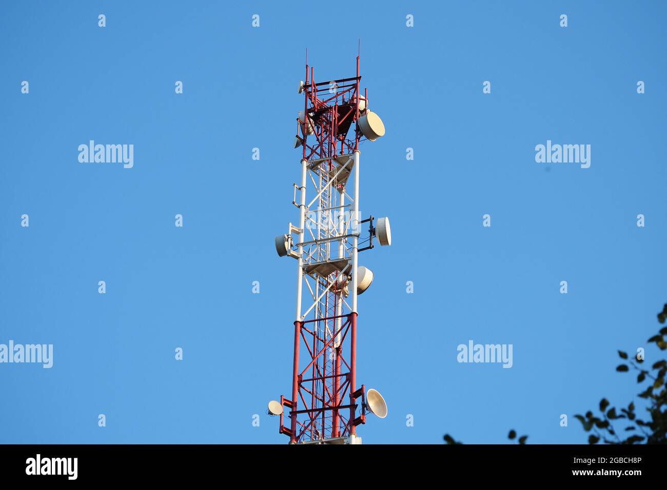 Torre per telecomunicazioni con antenna di rete cellulare 5G su sfondo blu. Foto di alta qualità Foto Stock