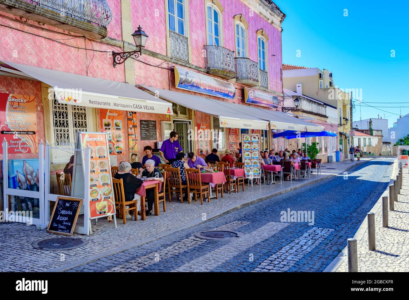 Caffè ristorante con pavimento in strada lungo la tradizionale strada acciottolata di calcada Silves Algarve Portugal Foto Stock