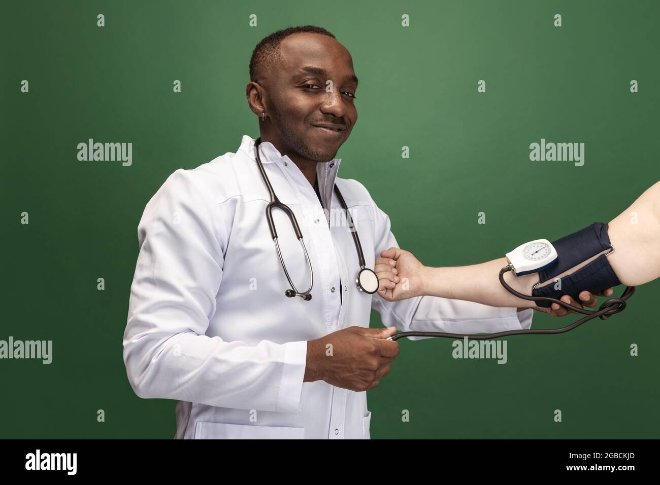 Immagine di giovane medico africano, consulente terapeutico o medico isalato su sfondo verde. Concetto di salute, cura e medicina. Primo piano Foto Stock