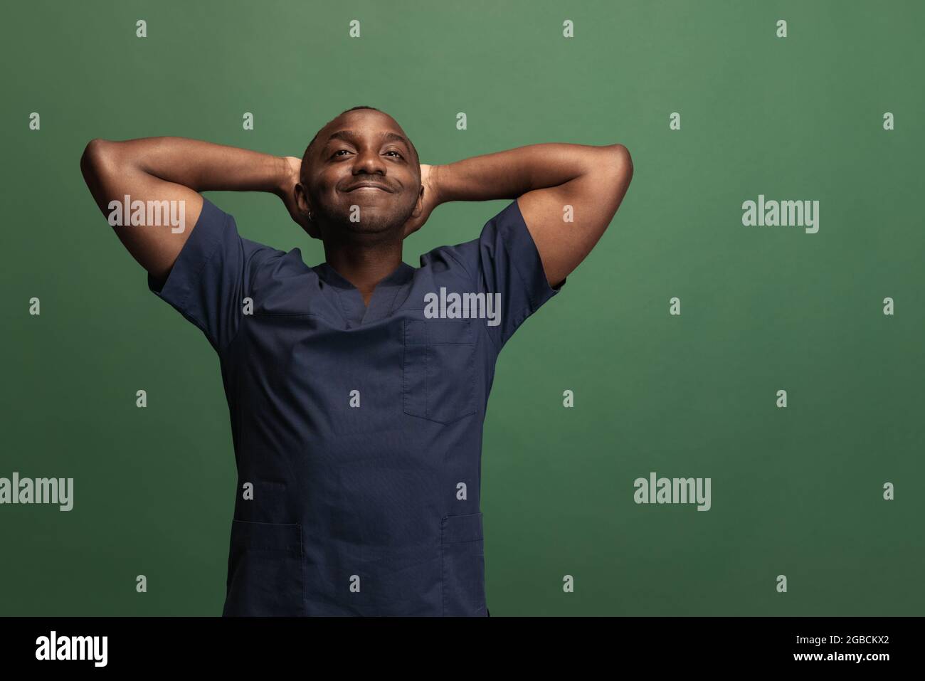 Immagine di giovane medico africano, consulente terapeutico o medico isalato su sfondo verde. Concetto di salute, cura e medicina. Primo piano Foto Stock