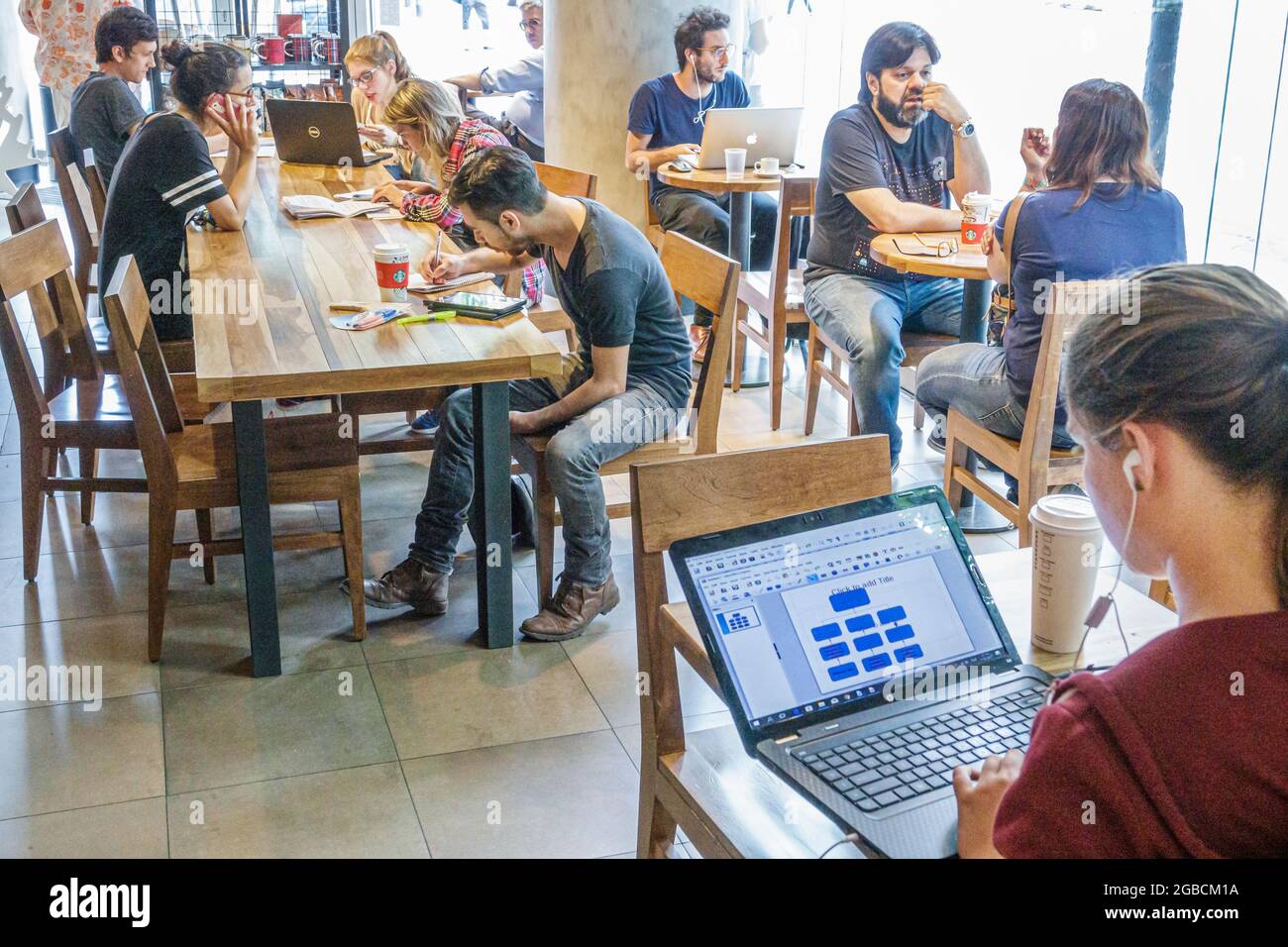 Argentina Buenos Aires Starbucks Coffee cafe coffee house, interno clienti Wi-Fi gratuito computer portatile utilizzando, ragazze ragazzi studenti teen teen Foto Stock
