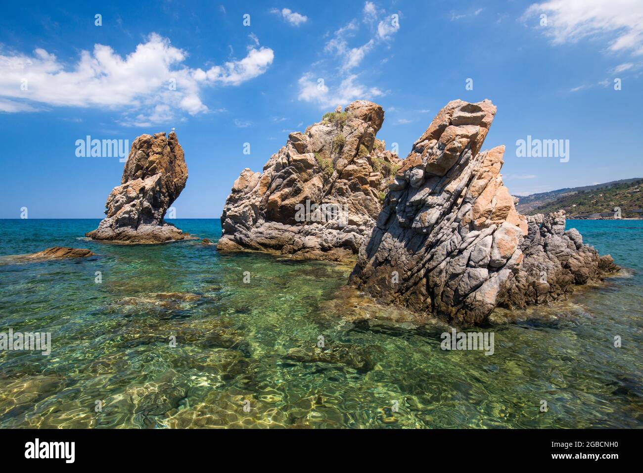 Cefalù, Palermo, Sicilia, Italia. Torreggianti formazioni rocciose che si innalzano dalle acque cristalline della Baia di Calura, un'insenatura riparata del Mar Tirreno. Foto Stock
