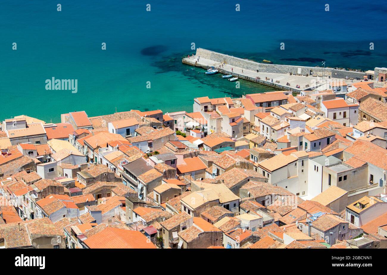 Cefalù, Palermo, Sicilia, Italia. Vista sui tetti piastrellati della Città Vecchia da la Rocca, le acque turchesi del Mar Tirreno oltre. Foto Stock