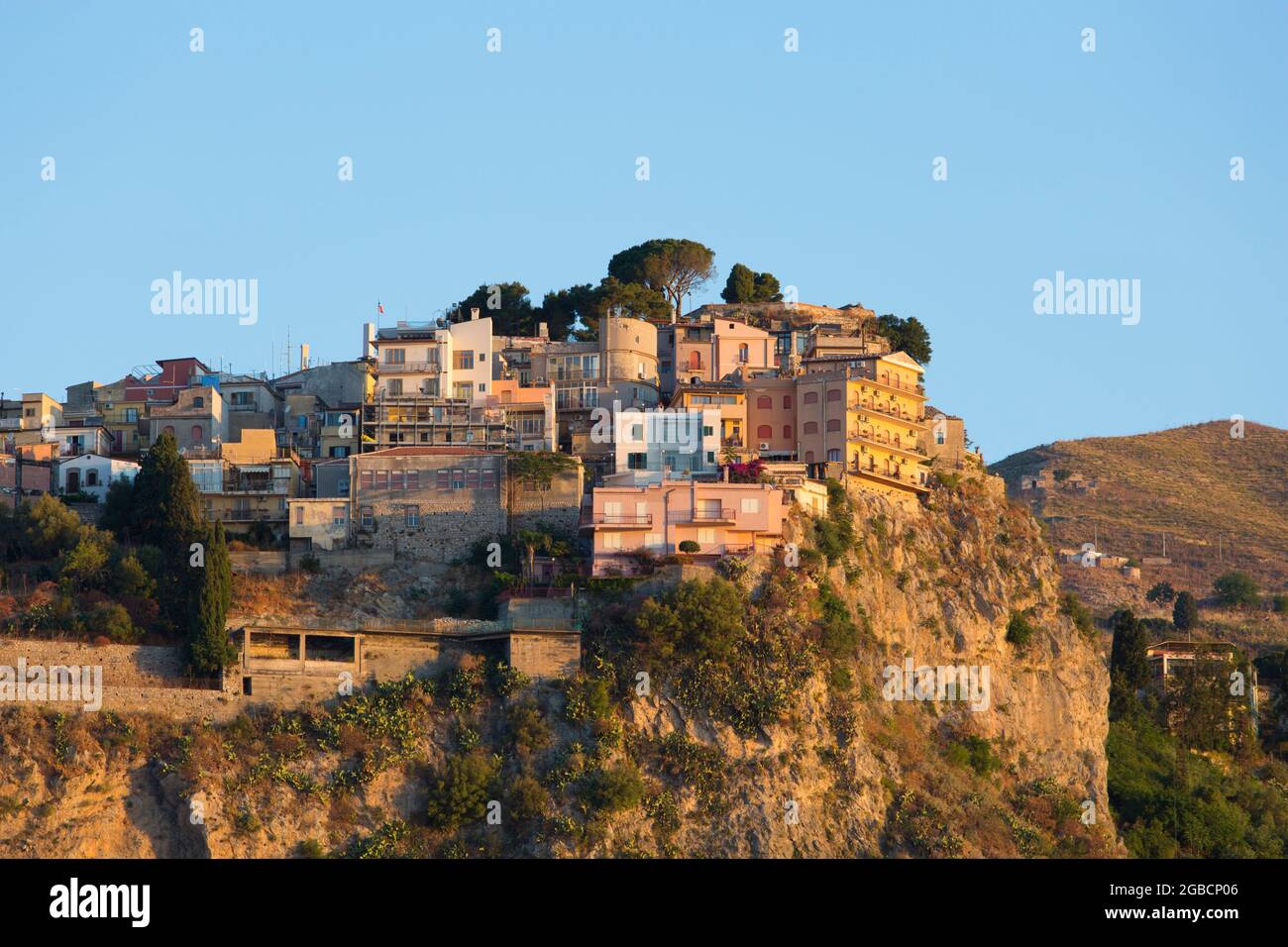 Taormina, Messina, Sicilia, Italia. Vista sul grazioso borgo medievale di Castelmola, alba, case precariosamente arroccate aggrappate alla scogliera. Foto Stock