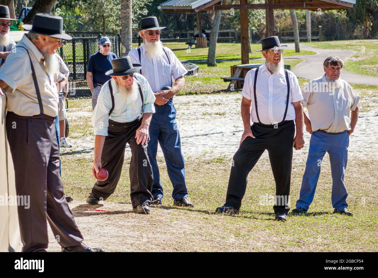 Sarasota Florida, Pinecraft Amish Mennonite gruppo, comunità inverno ritiro Pinecraft Park, adulti uomini amici, giocare bocce palla gioco clothi tradizionale Foto Stock