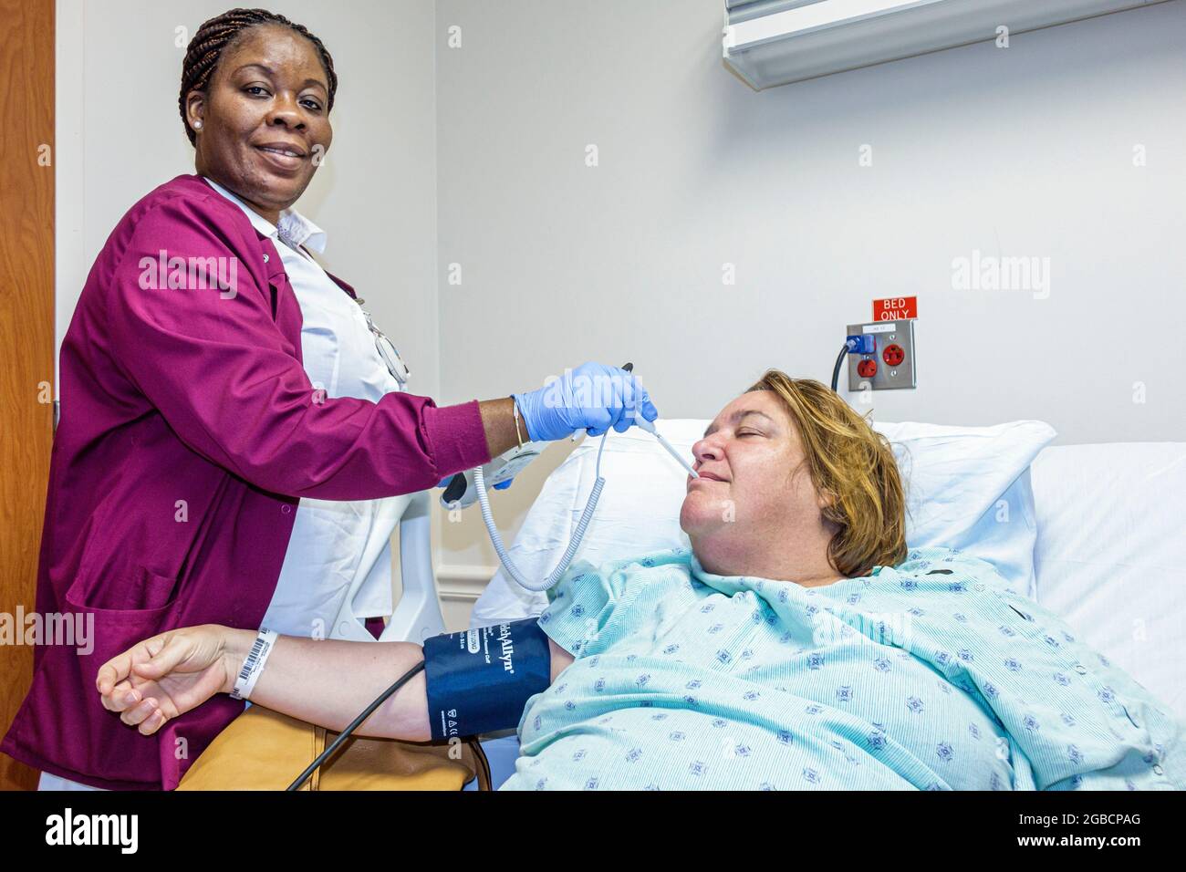 Miami Beach Florida, Mount Mt. Sinai Medical Center ospedale ispanico paziente, donna nera donna donna donna donna donna donna infermiere prendere temperatura pressione sanguigna, Foto Stock