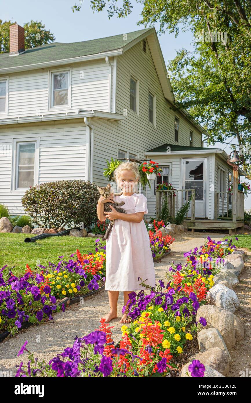 Indiana Shipshewana, Amish Farm Tour, ragazza bambino tiene casa kitten in piedi davanti all'esterno, Foto Stock