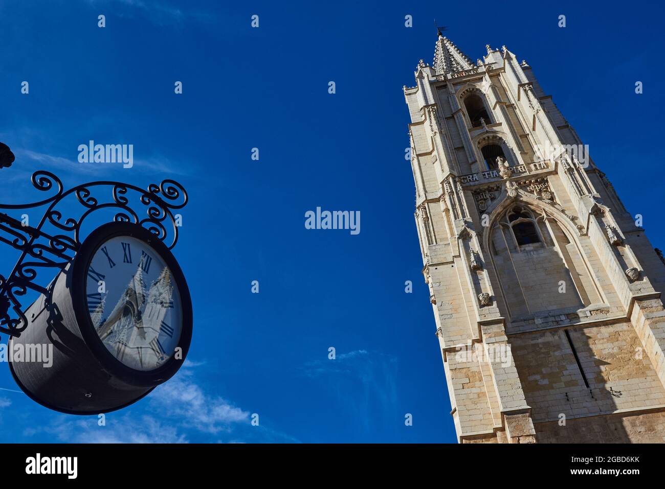 Vista della torre della Cattedrale di Leon e orologio moderno in primo piano. Città di Castiglia, in Spagna. Foto Stock