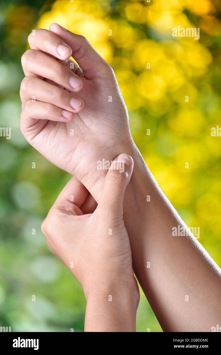 Digitopressione concetto, femmina facendo stesso, contro verde bellissimo sfondo all'aperto Foto Stock