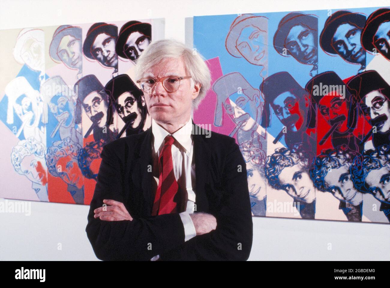 L'artista pop americano Andy Warhol, ritratto di mezza lunghezza di fronte alla schermata di Marx Brothers della sua serie dieci ritratti di ebrei del XX secolo, Museo Ebraico, New York City, New York, USA, Bernard Gotfryd, 1980 Foto Stock