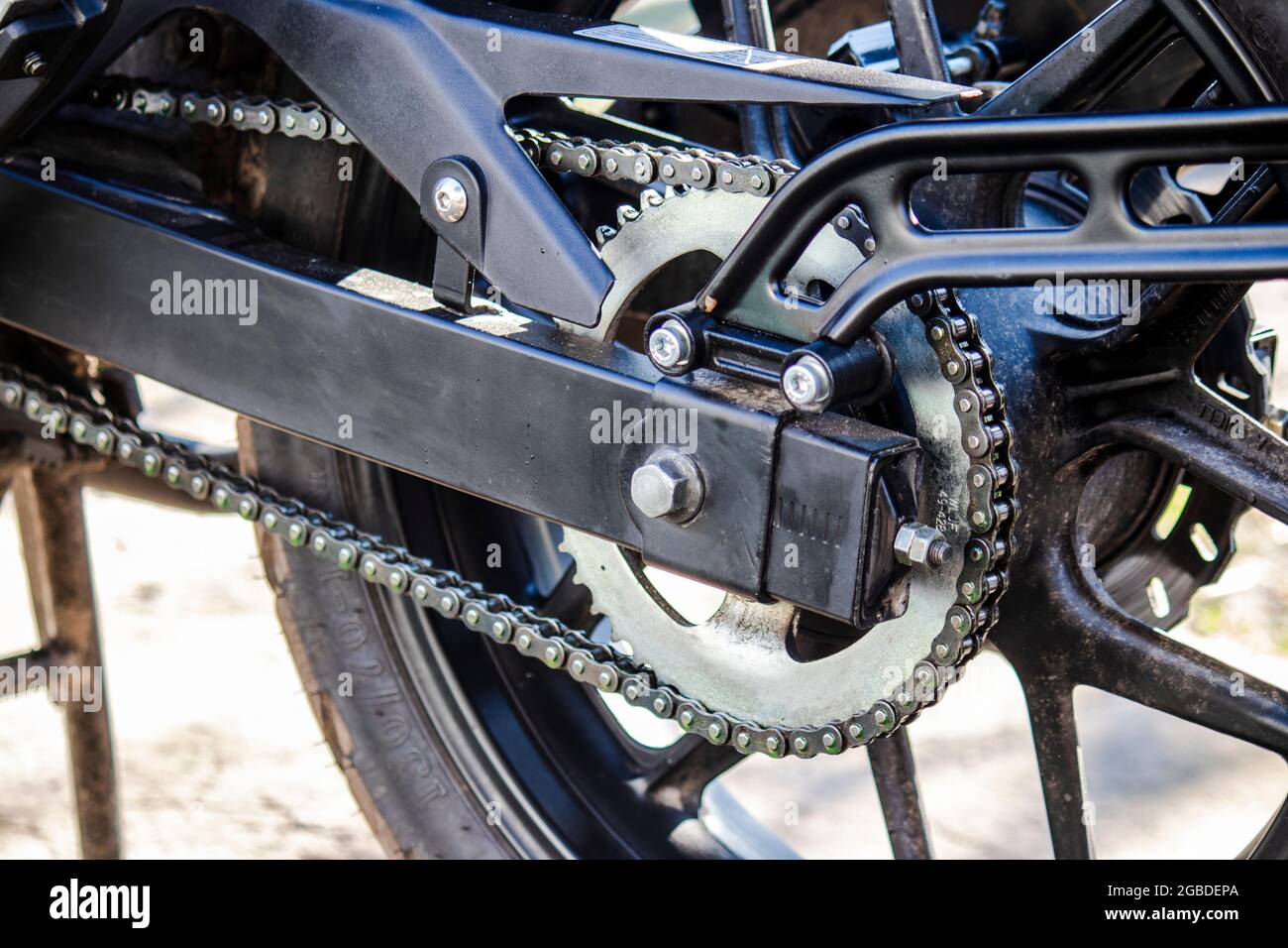 La parte posteriore di una moto con una ruota, una stella del pendolo e una chiusura a catena. Manutenzione e riparazione di autoveicoli. Foto Stock