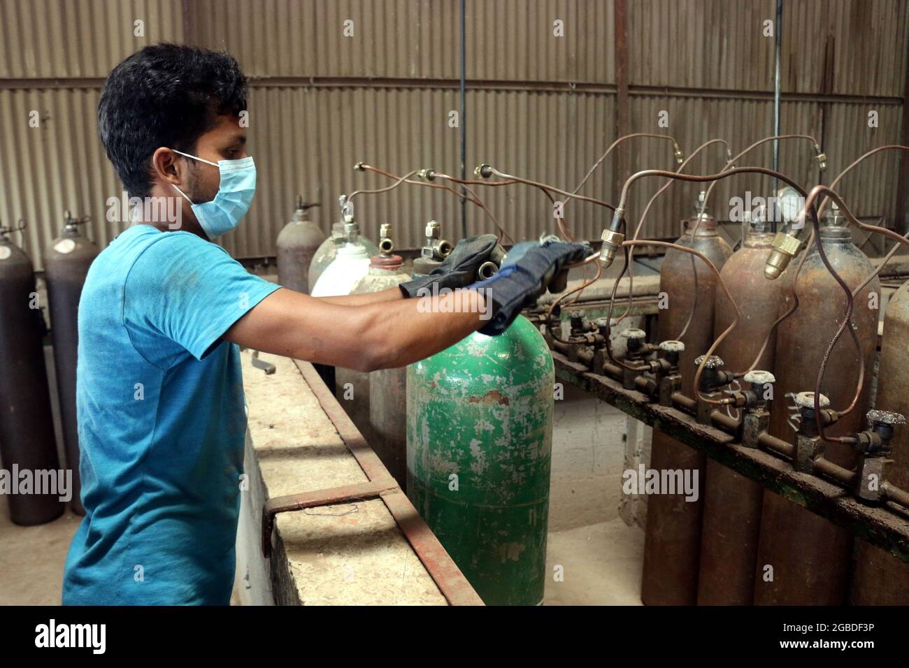 Dhaka, Bangladesh, 3 agosto 2021: Un lavoratore ricarica serbatoi di ossigeno in una fabbrica, per la fornitura di ossigeno medico agli ospedali per il trattamento di pazienti COVID-19, durante una seconda ondata di infezioni, dopo che l'India ha fermato l'esportazione dovuto aumento COVID-19 casi positivi dalla variante Delta, rilevato per la prima volta in India. Credit: Habibur Rahman / Eyepix Group/Alamy Live News Foto Stock
