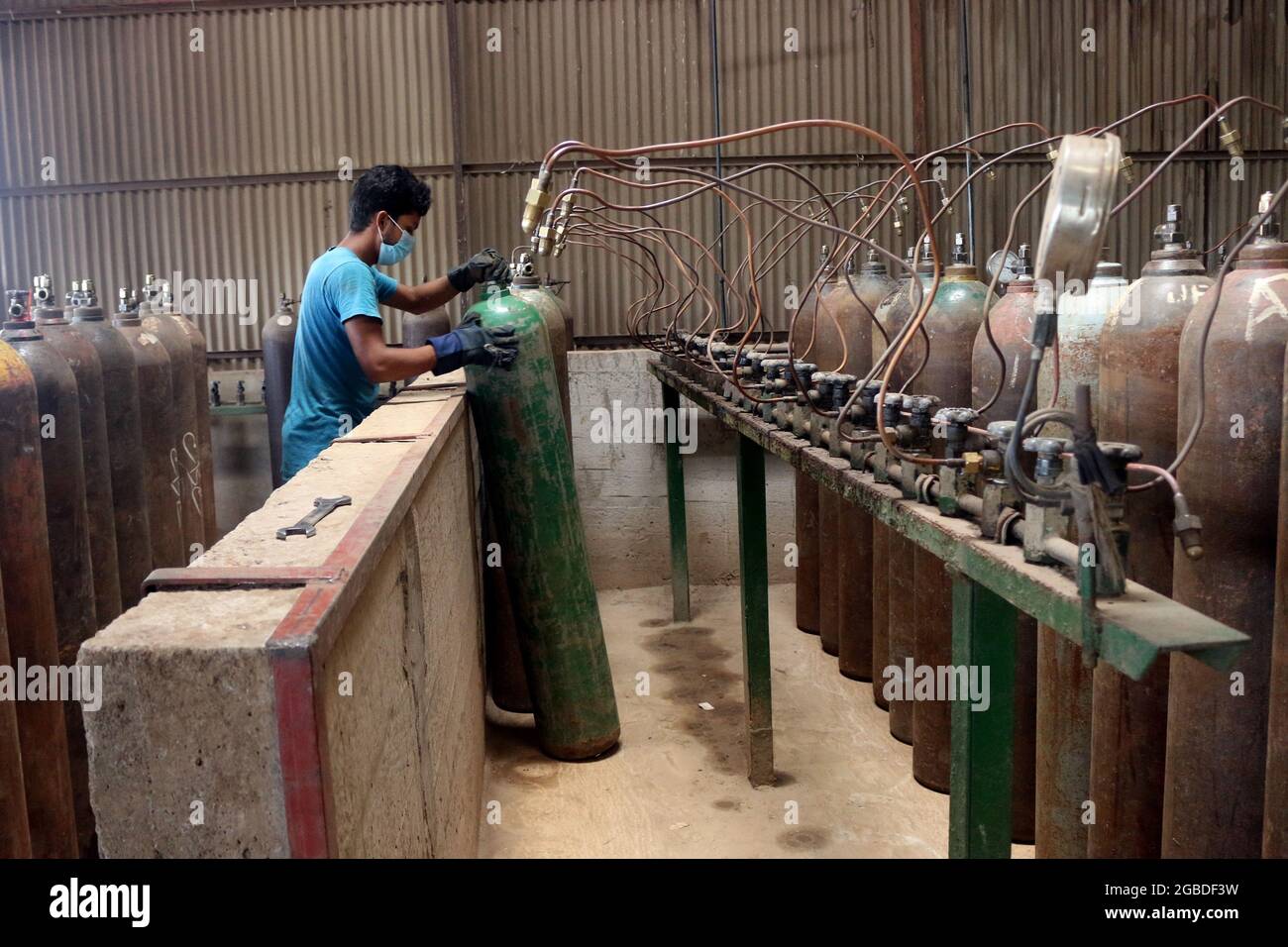 Dhaka, Bangladesh, 3 agosto 2021: Un lavoratore ricarica serbatoi di ossigeno in una fabbrica, per la fornitura di ossigeno medico agli ospedali per il trattamento di pazienti COVID-19, durante una seconda ondata di infezioni, dopo che l'India ha fermato l'esportazione dovuto aumento COVID-19 casi positivi dalla variante Delta, rilevato per la prima volta in India. Credit: Habibur Rahman / Eyepix Group/Alamy Live News Foto Stock