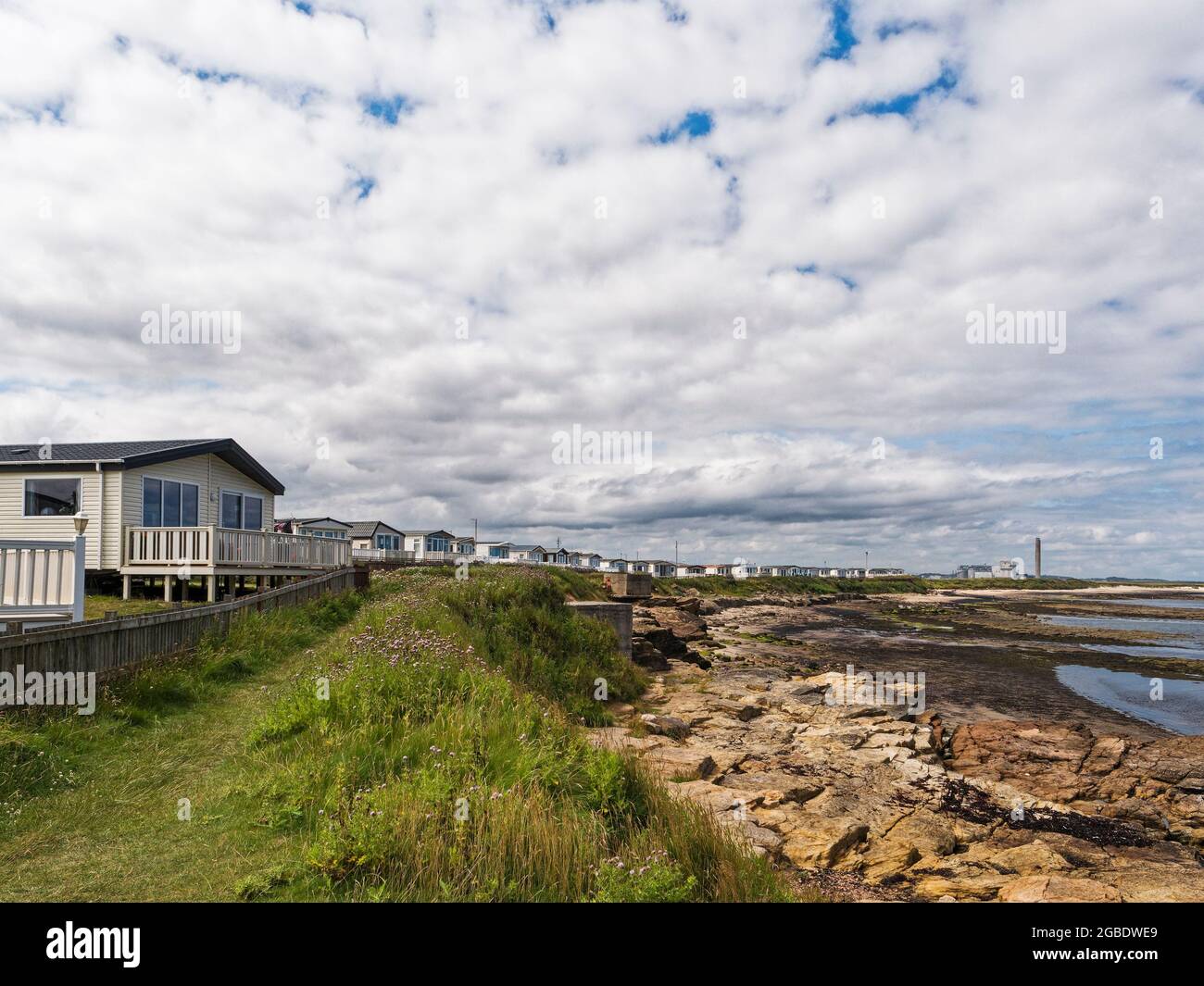 Vista del Church Point Holiday Park a Newbiggin dal mare a bassa marea con centrale elettrica e spazio per fotocopie. Foto Stock