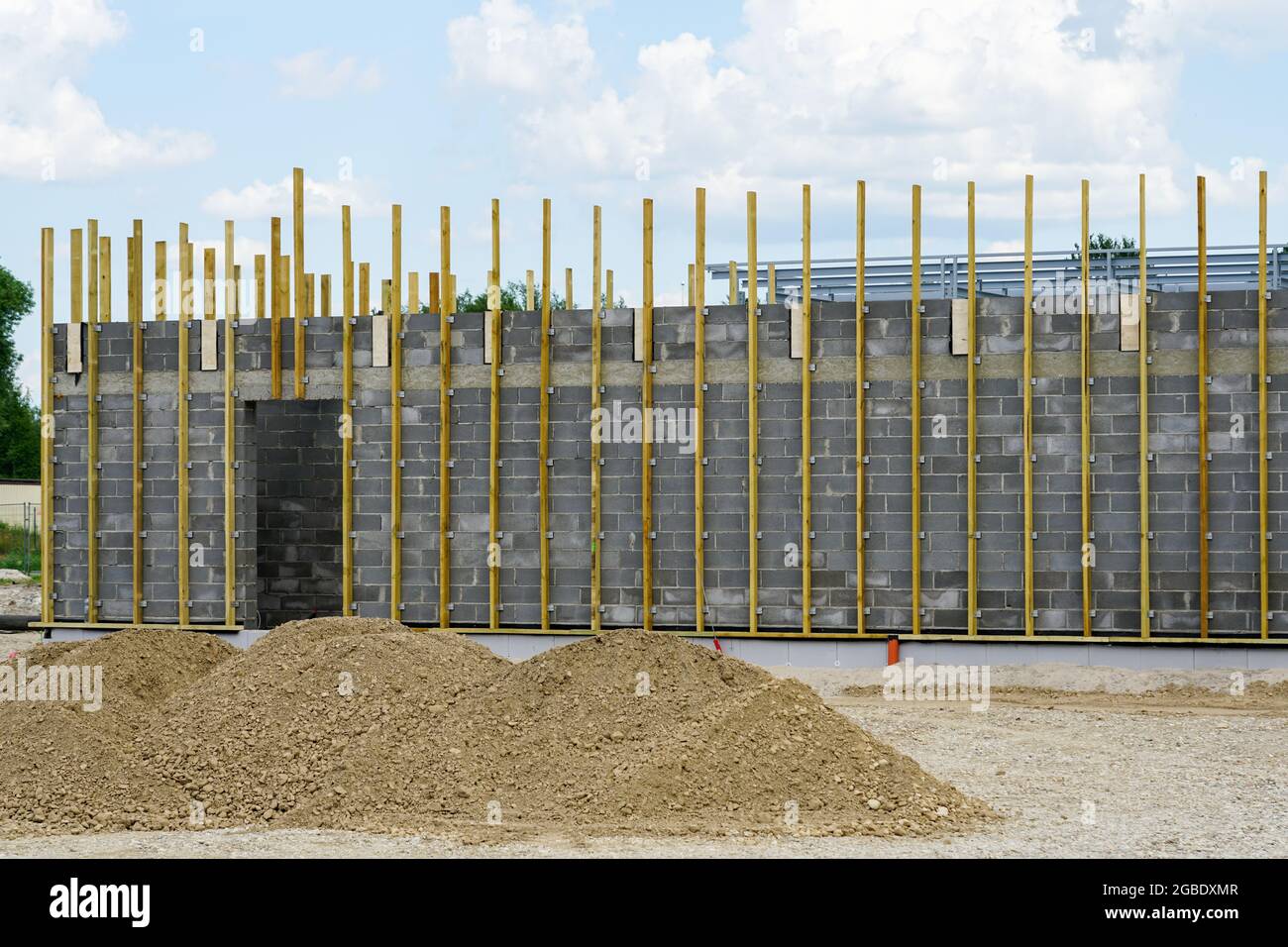la facciata di un nuovo edificio costruito con blocchi da costruzione con listelli in legno per il fissaggio di isolamento termico e pannelli decorativi Foto Stock