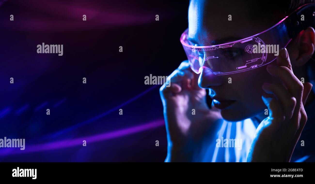 Ritratto di una giovane donna che usa occhiali digitali futuristici Foto Stock