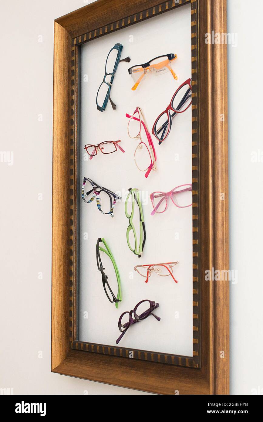 Vista angolare di una cornice espositore piena di occhiali da vista con cornici colorate o solo montature di occhiali alla moda e alla moda Foto Stock