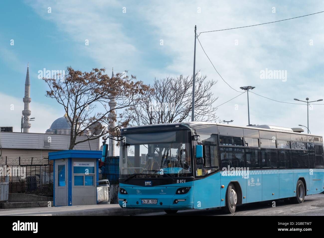 Eminonu, Istanbul, Turchia - 02.18.2021: Primo piano di un autobus blu comunale parcheggiato in deposito autobus di fronte alla moschea minareti e stazione con copia spac Foto Stock