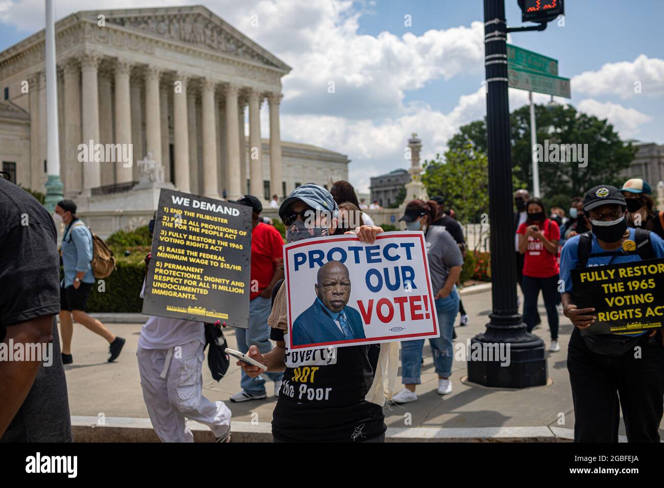 I manifestanti marciano di fronte al Palazzo della Corte Suprema con un poster con una foto dell'attivista per i diritti civili e del rappresentante americano John Lewis. Il 2 agosto 2021, la Campagna dei poveri si è radunata e ha marciato a Washington DC, dove leader di fede, lavoratori a basso salario e poveri di tutto il paese hanno protestato affinché il Senato degli Stati Uniti porgessi fine al ostruzionismo, protegga i diritti di voto e aumenti il salario minimo federale a 15 dollari l'ora. Centinaia di persone sono state arrestate in un atto non violento di disobbedienza civile al di fuori dell'edificio del Senato Hart. (Foto di Michael Nigro/Pacific Press) Foto Stock