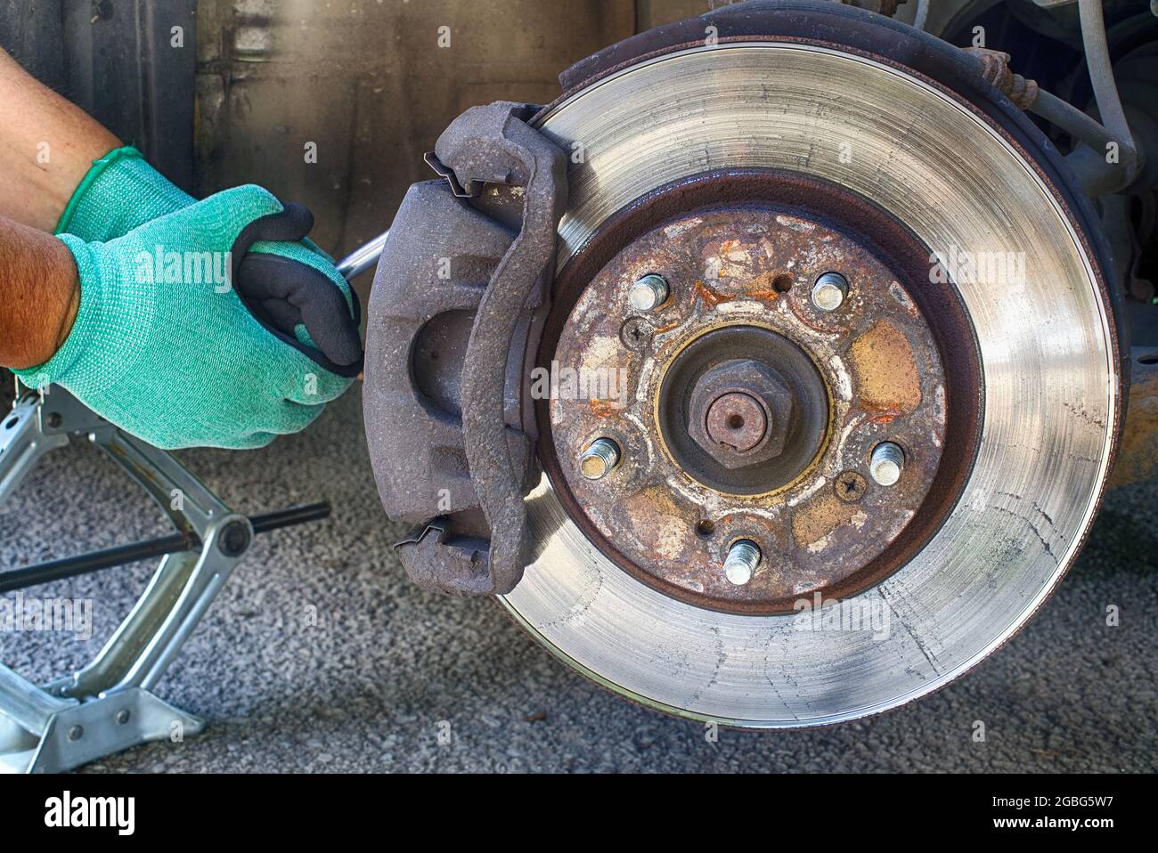 Chiudere il servizio di sostituzione delle pastiglie dei freni del disco  auto con la mano del meccanico, il rotore dei dischi dei freni senza ruote  Foto stock - Alamy