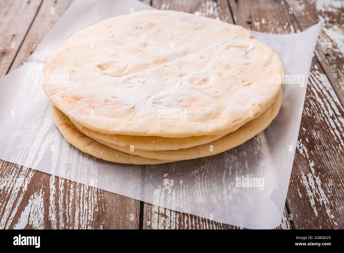 Pane piatto, pita o crosta di pizza su tavola di legno della cucina Foto Stock