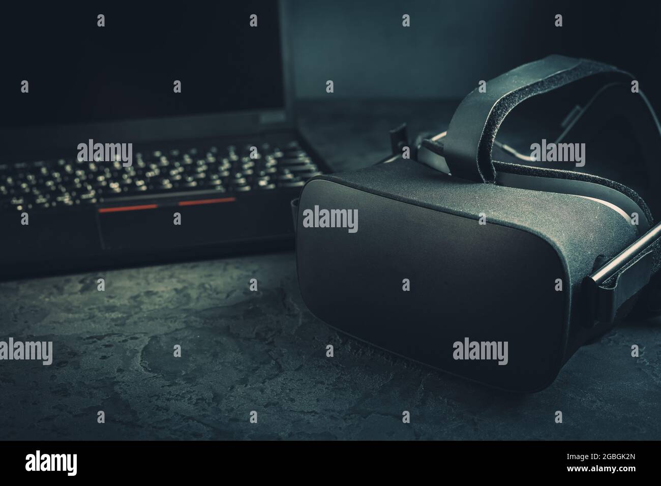 Visore VR: Occhiali per la realtà virtuale per la simulazione della realtà per diversi contenuti multimediali con il laptop in background Foto Stock