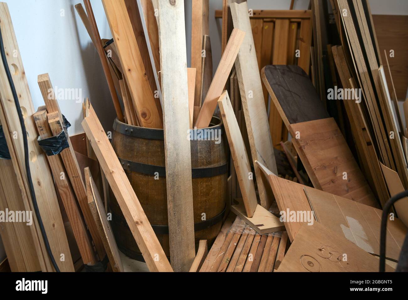 Stoccaggio di scarti di legno, listelli, listelli e tavole nell'officina di un artigiano, fuoco selezionato, profondità di campo ristretta Foto Stock