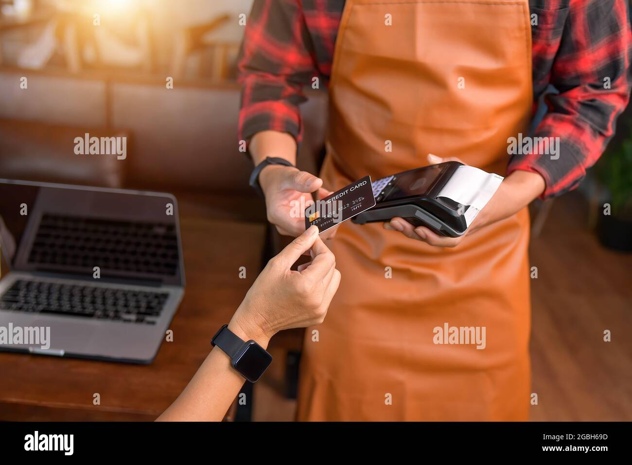 Donna che effettua un pagamento senza contatto su un lettore di carta di credito Foto Stock