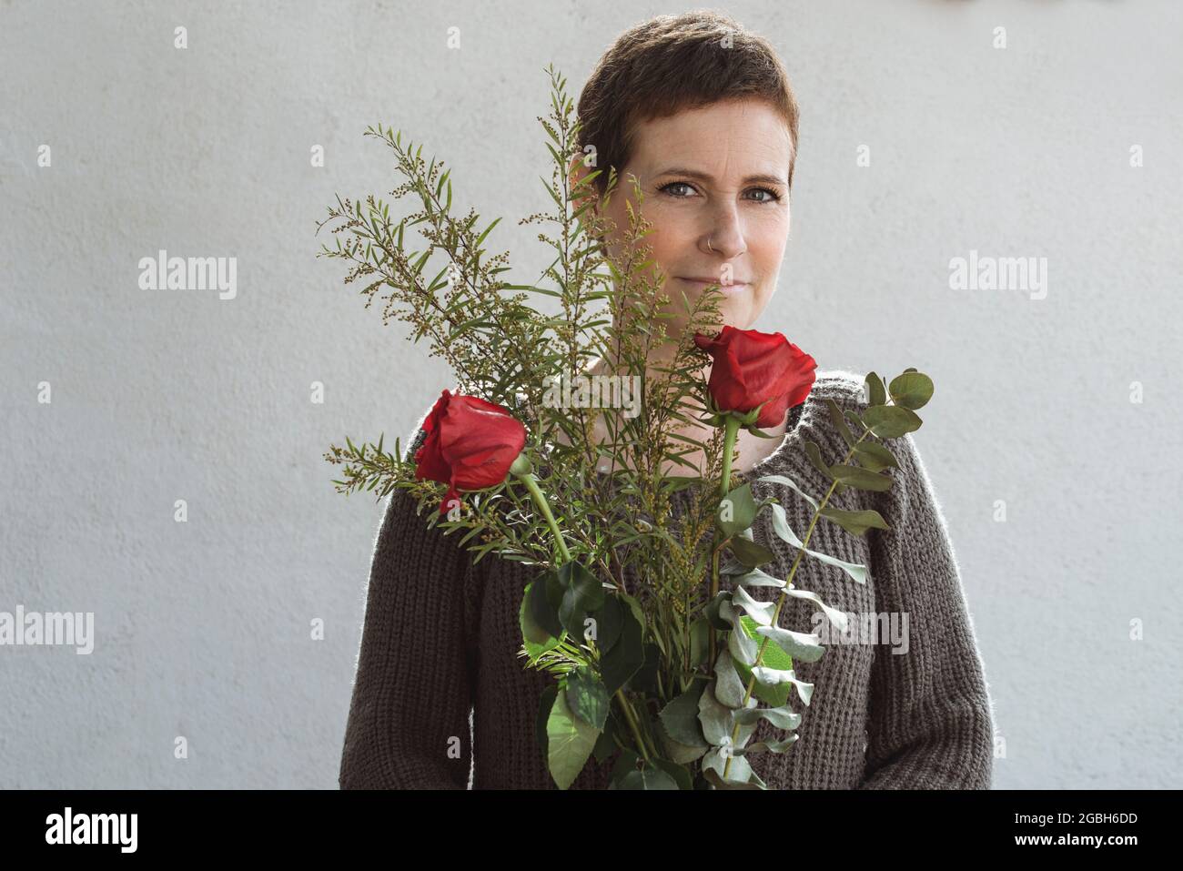 Ritratto di una donna sorridente tenendo un mazzo di fiori Foto Stock