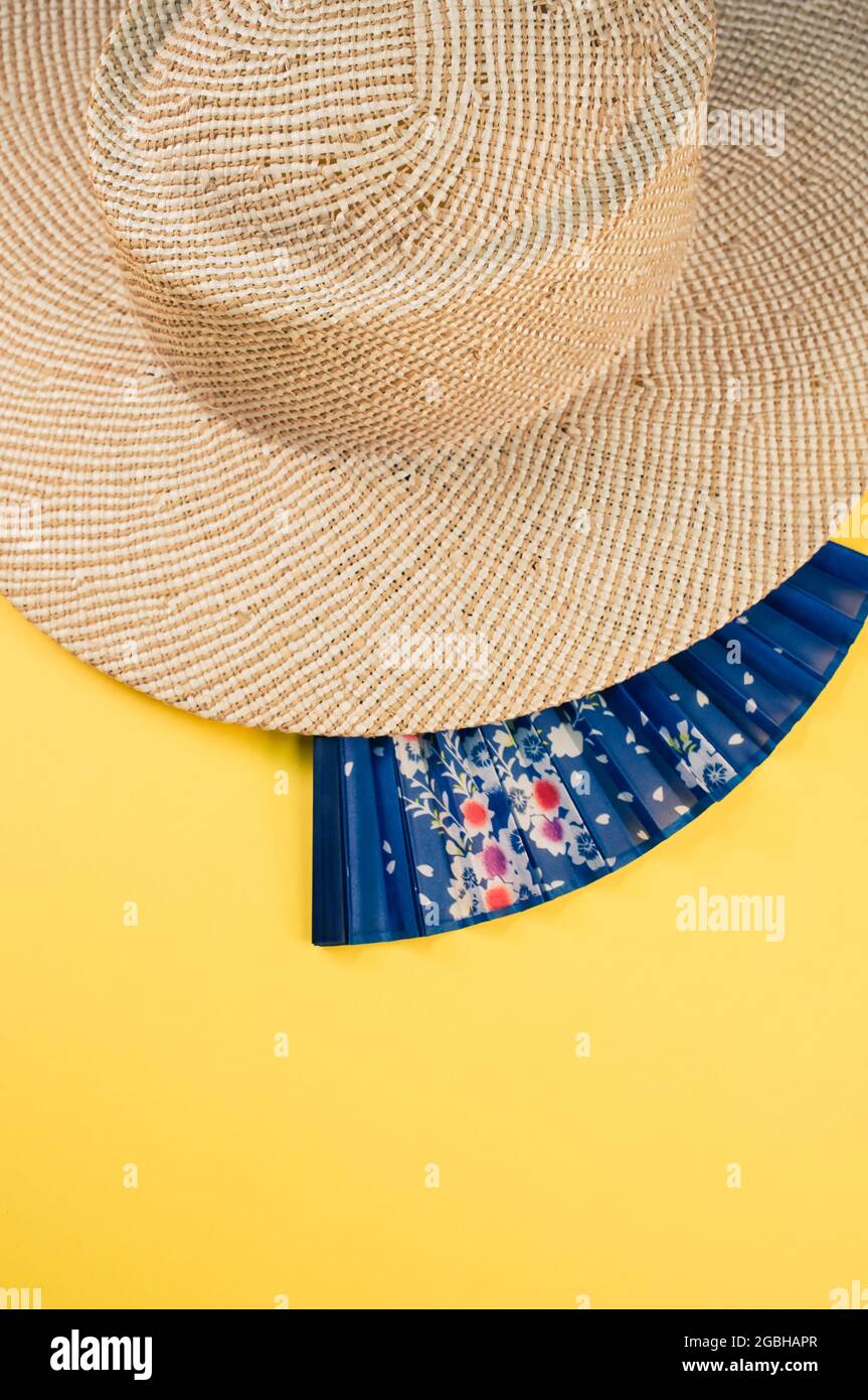 Cappello di paglia rotondo e un ventilatore blu isolato su sfondo giallo  con spazio libero per il testo Foto stock - Alamy