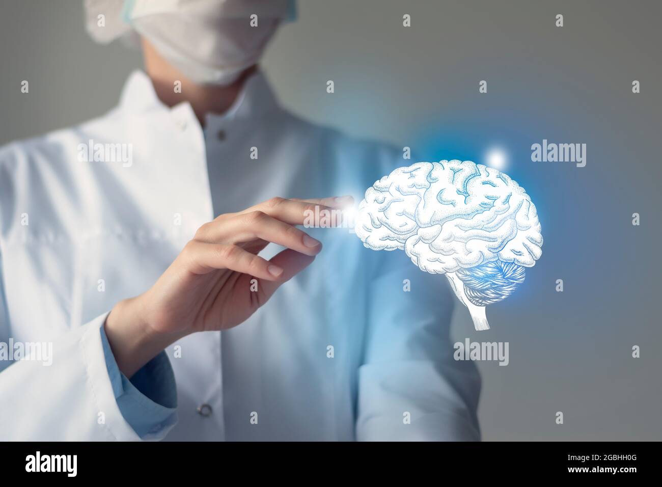 Il medico femminile tocca il cervello virtuale in mano. Foto sfocata, organo umano lavorato a mano, evidenziato in blu come simbolo di guarigione. Assistenza sanitaria ospedaliera Foto Stock
