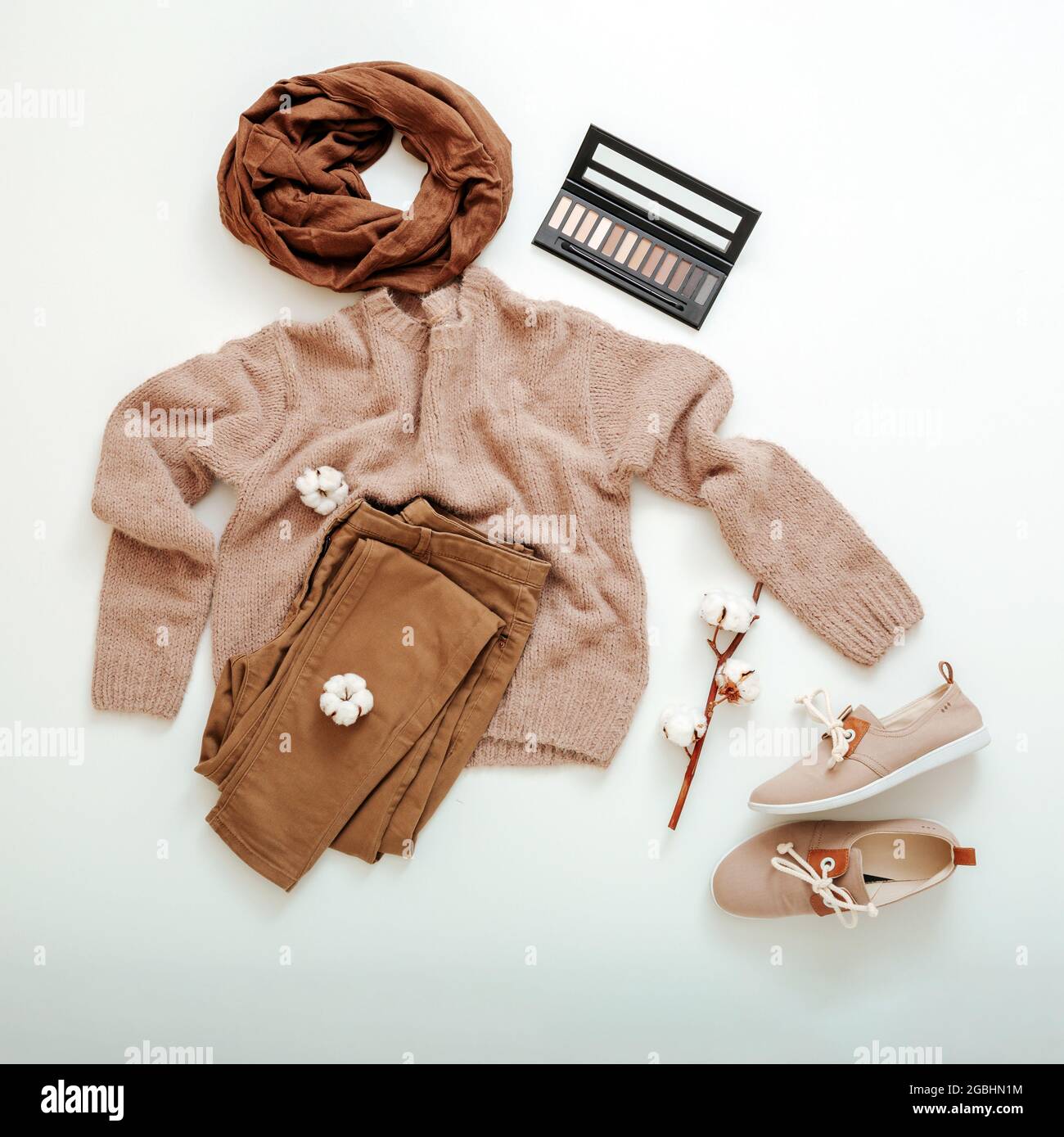 Fashion Basic abbigliamento donna set scarpe beige marrone colori maglia sciarpa e fiori di cotone cosmetici. Piatto Lay primavera inverno donna femmina Foto Stock