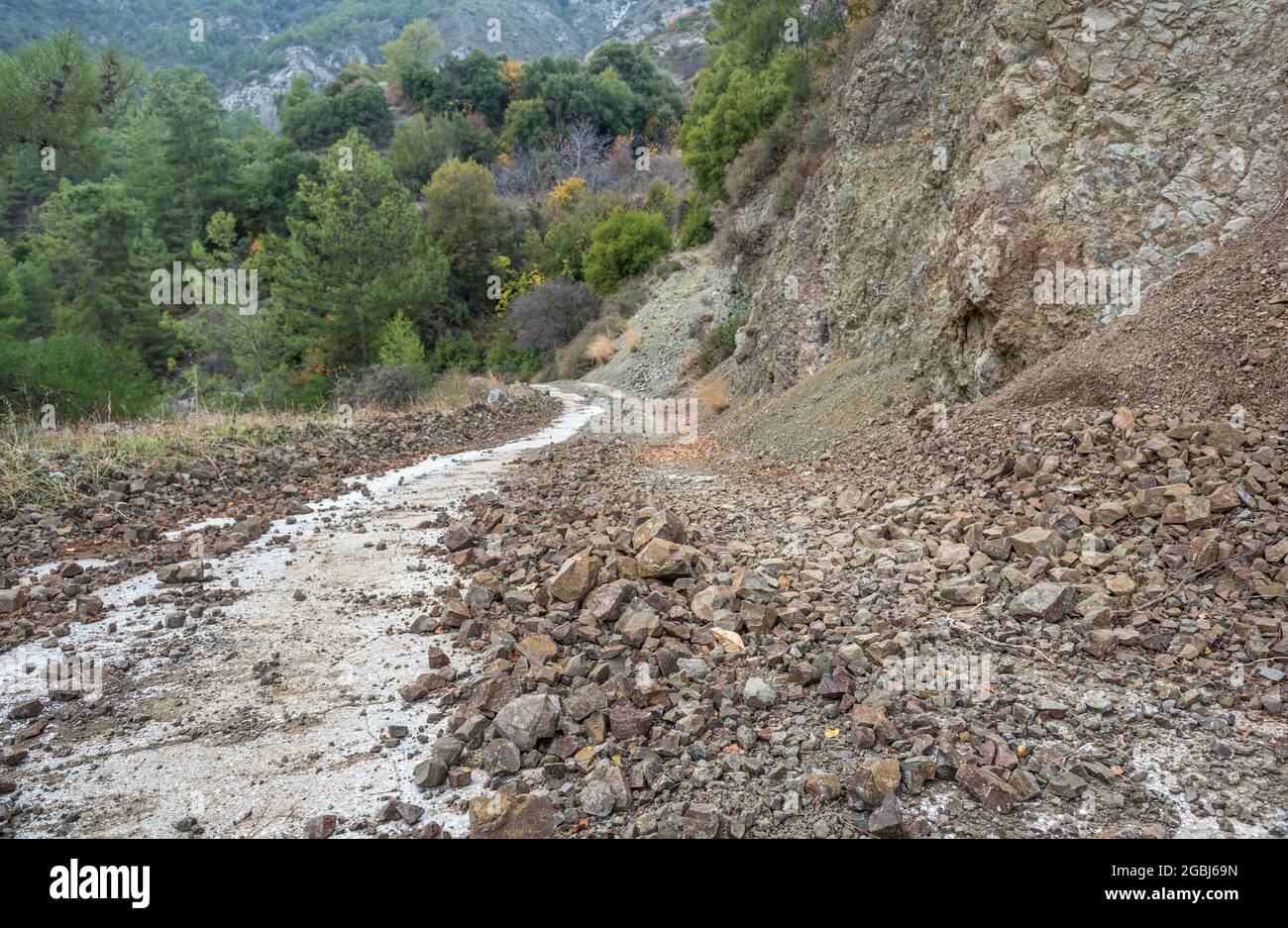 Pericolo di caduta delle rocce. Strada di campagna bloccata da una caduta nella zona di montagna di Cipro Foto Stock