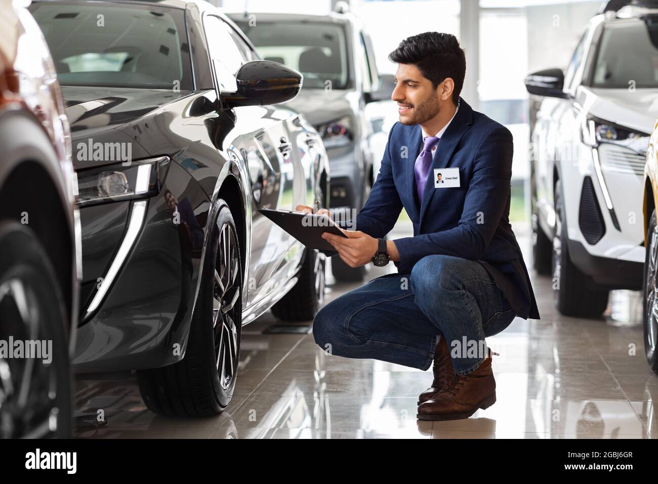 Medio-orientale Guy responsabile vendite in salone auto fare il controllo Foto Stock