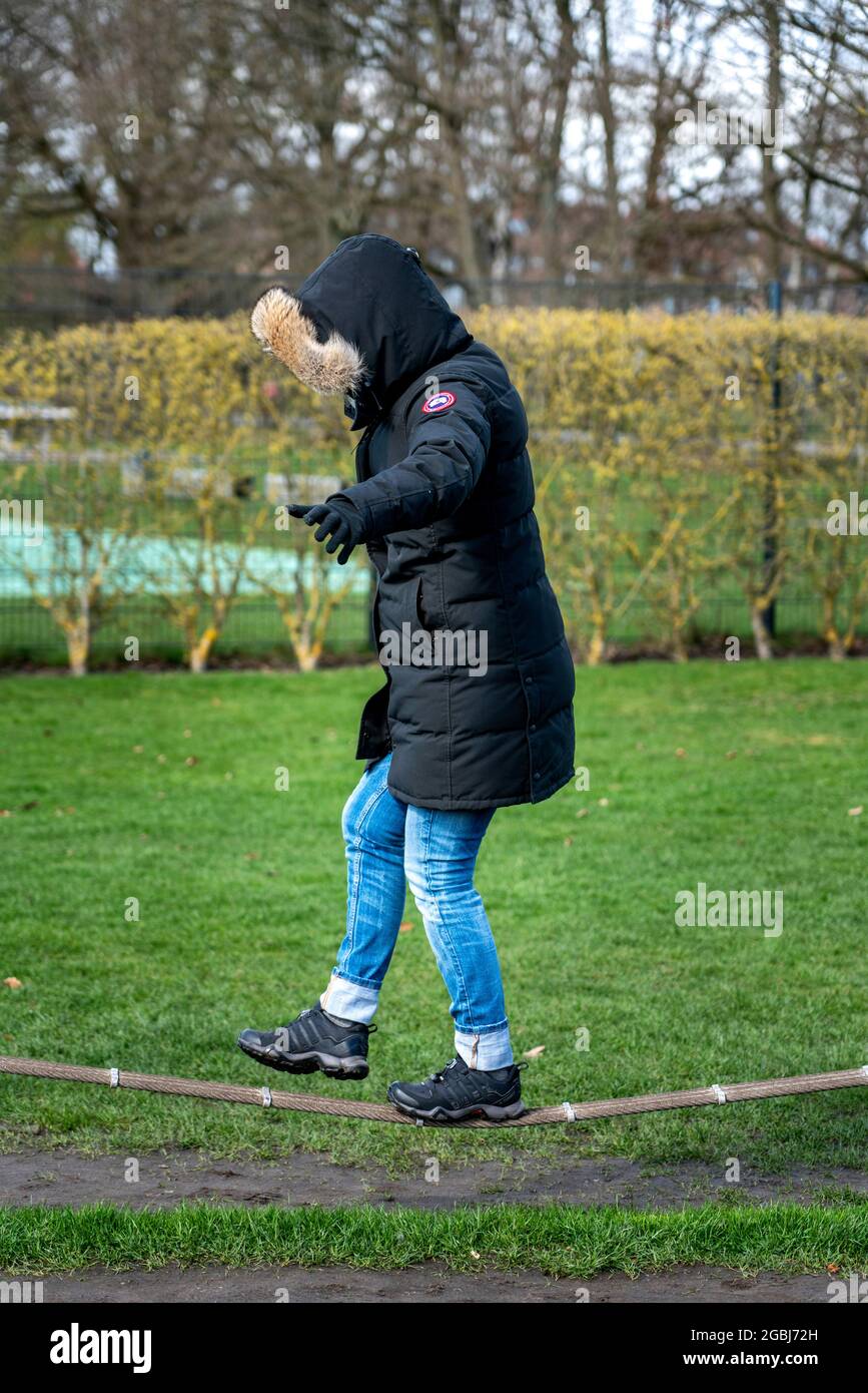 Una donna balance su una corda nel parco Foto Stock