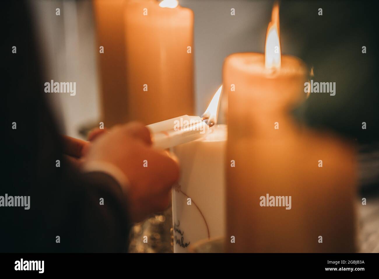 Primo piano delle mani di coppia che bruciano le candele Foto Stock