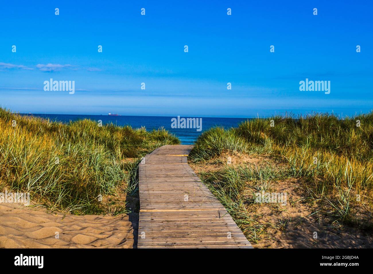 Passerella in legno attraverso le dune di sabbia fino al mare Foto Stock