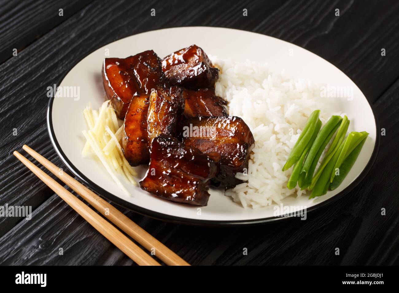 Piatto di pancia di maiale brasato di Rafute Okinawan che viene bollito in awamori, zucchero nero e salsa di soia nel piatto sul tavolo. Orizzontale Foto Stock