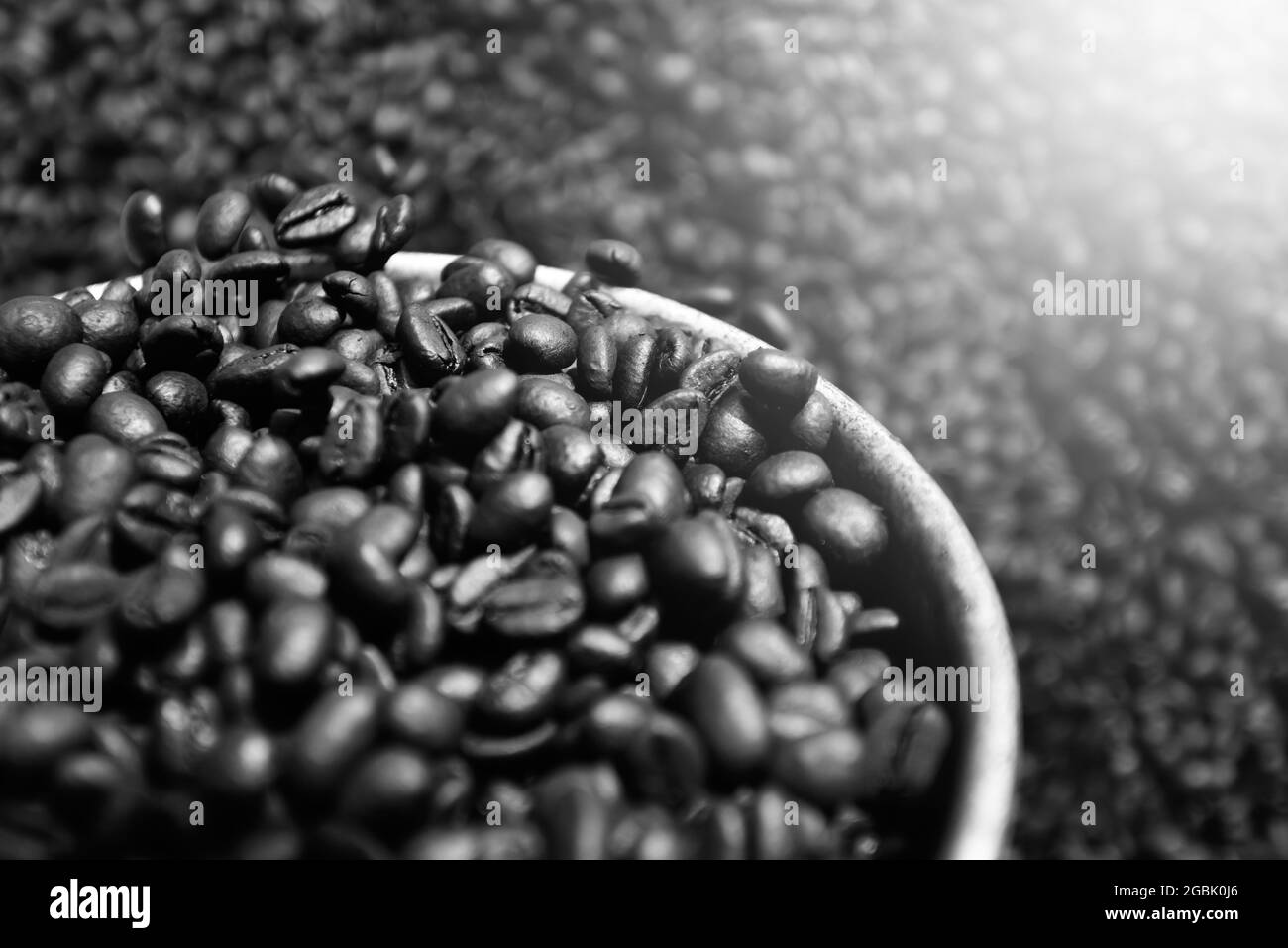 Chicchi di caffè con texture fresche tostate. Chicchi di caffè arrostiti su paletta in argento in modo tradizionale asiatico. Primo piano. Vista dall'alto. Disposizione piatta. Messa a fuoco selettiva. Foto Stock