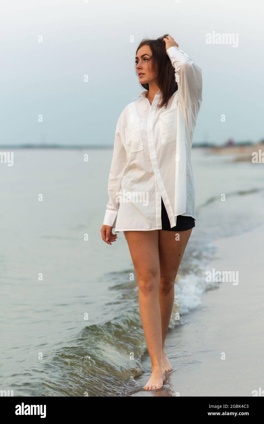 Giovane bella moda ragazza in camicia bianca. Vacanza al mare.Romantic  giovane donna su blu naturale sfondo estate all'aperto Foto stock - Alamy