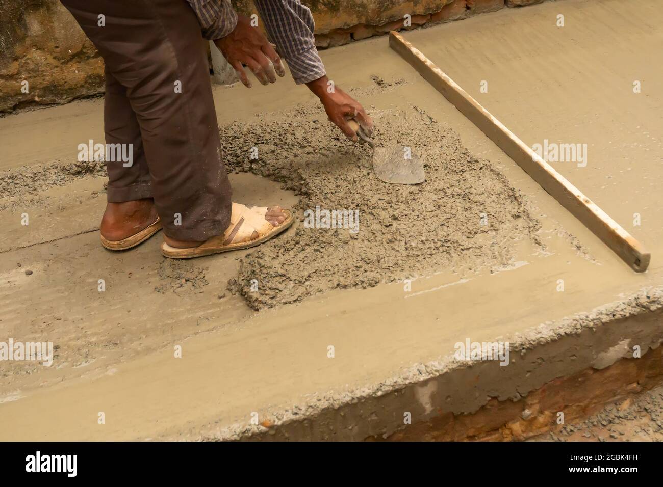 Lavoratori edili indiani intonacare pavimento utilizzando cazzuola e cemento manualmente, immagine stock. Foto Stock