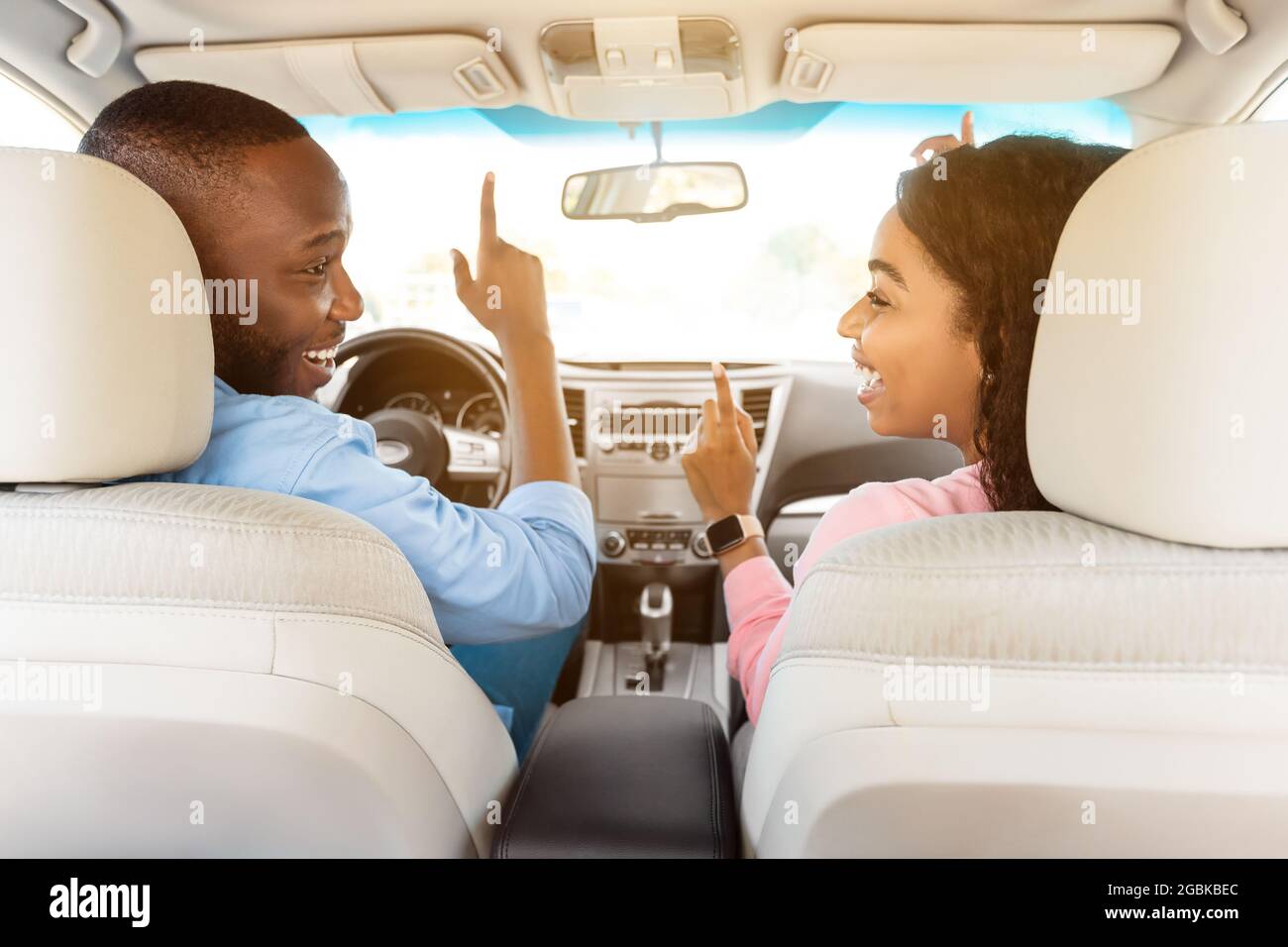 Felice coppia nera godendo la musica guidando l'automobile piacevole Foto Stock