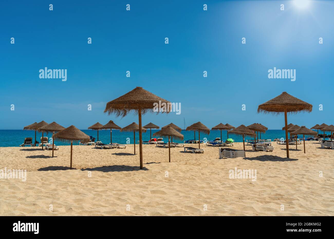 Vista sulla spiaggia di lusso sul mare con lettini e ombrelloni, nella zona turistica dei tropici. Giorno di sole Foto Stock